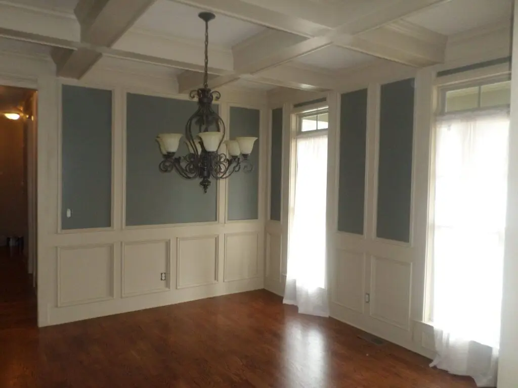 Dining room with neutral walls and white wainscoting